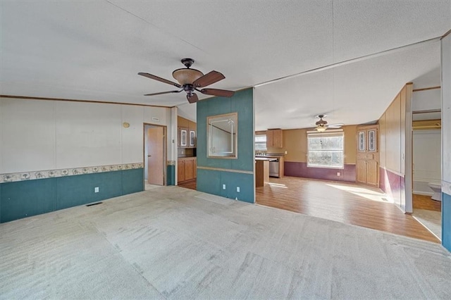 unfurnished living room with ceiling fan and light carpet