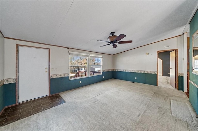 unfurnished living room featuring ceiling fan, dark carpet, crown molding, and a textured ceiling