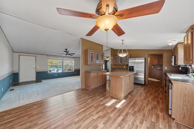 kitchen featuring hanging light fixtures, hardwood / wood-style floors, a kitchen island, and stainless steel appliances