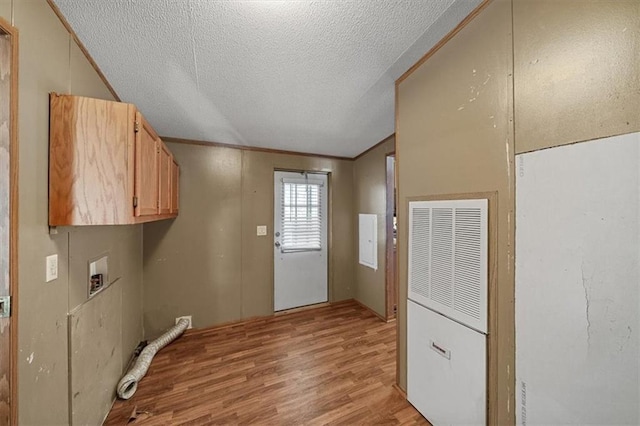 laundry room with cabinets, hookup for a washing machine, light hardwood / wood-style floors, a textured ceiling, and ornamental molding