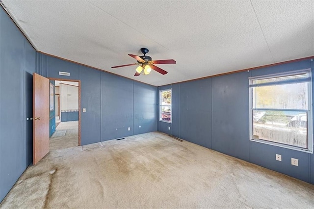 unfurnished bedroom with a textured ceiling, ceiling fan, light carpet, and vaulted ceiling