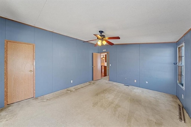 carpeted spare room with ceiling fan and a textured ceiling