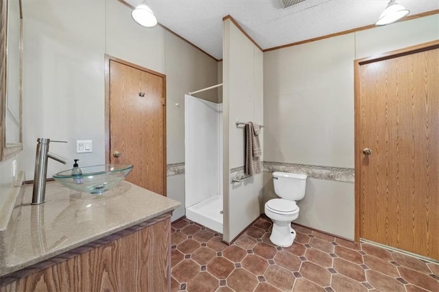 bathroom with a shower, a textured ceiling, vanity, and toilet