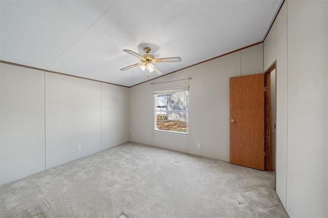 unfurnished room featuring a textured ceiling, ceiling fan, lofted ceiling, and light carpet