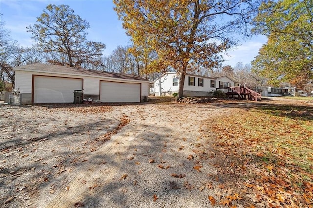 view of front of home with a garage, an outdoor structure, and a deck