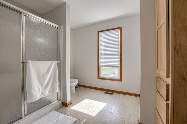 bathroom with toilet and a shower with shower door