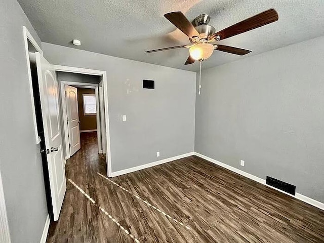 unfurnished bedroom featuring a textured ceiling, dark hardwood / wood-style floors, and ceiling fan