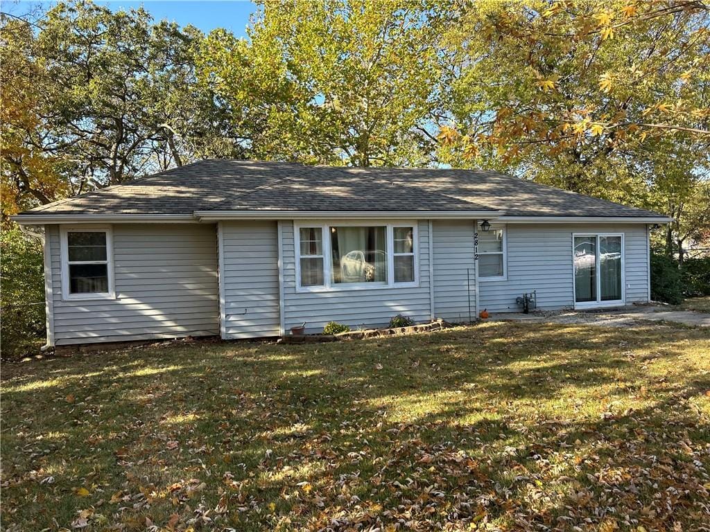 rear view of house featuring a lawn