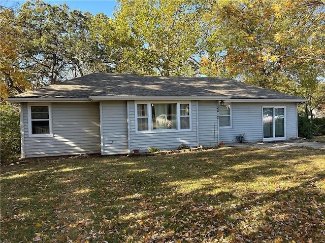 rear view of house featuring a lawn