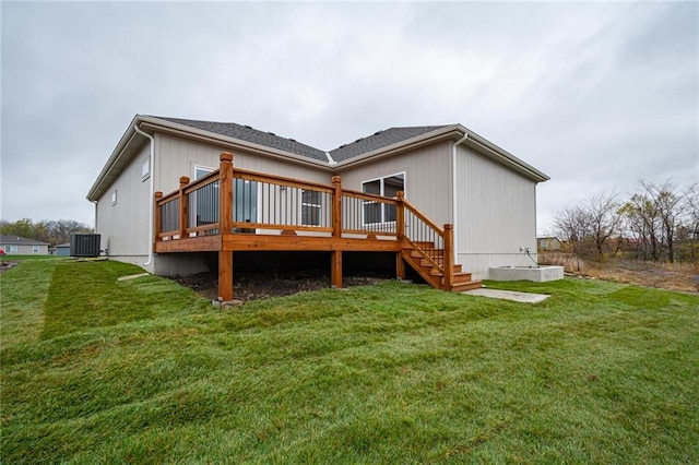 rear view of house with central AC unit, a yard, and a deck