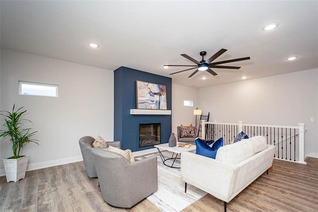 living room featuring hardwood / wood-style flooring and a large fireplace