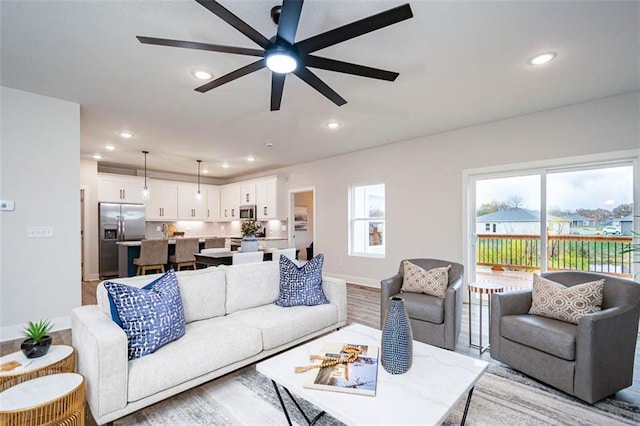 living room featuring ceiling fan and light wood-type flooring