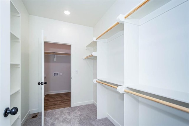 walk in closet featuring light carpet