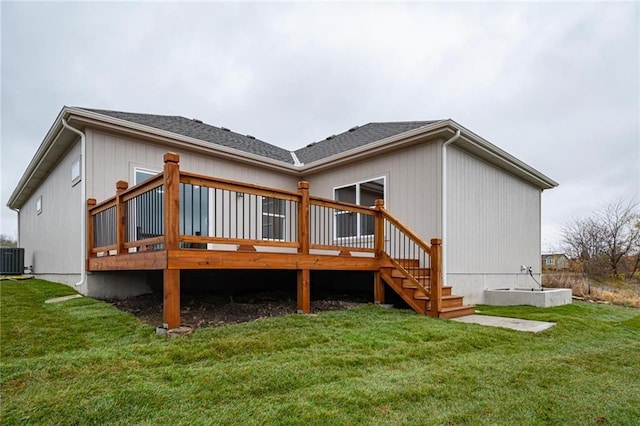 rear view of property featuring a yard, a shingled roof, a wooden deck, and central AC unit