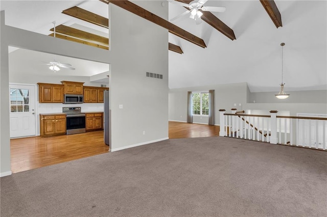 unfurnished living room with ceiling fan, beam ceiling, light hardwood / wood-style floors, and high vaulted ceiling