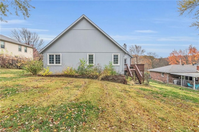 back of property featuring a lawn and a wooden deck