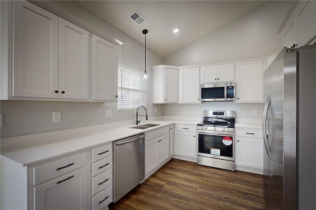 kitchen featuring sink, dark hardwood / wood-style floors, decorative light fixtures, lofted ceiling, and appliances with stainless steel finishes