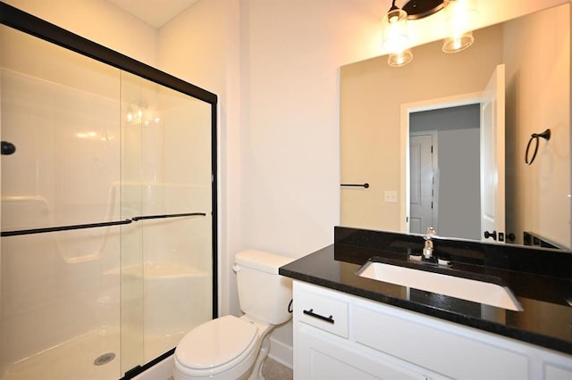 bathroom with vanity, a shower with shower door, and toilet