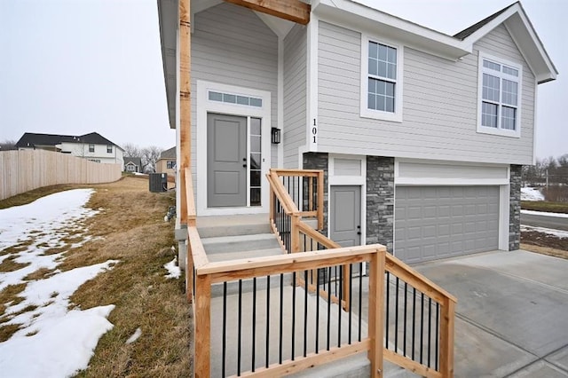 view of front of property with a garage and central AC