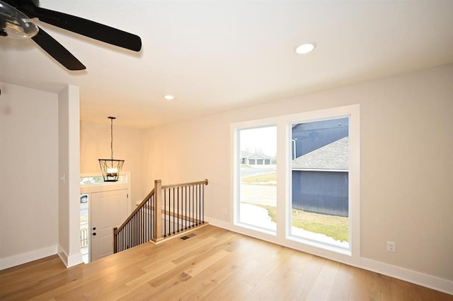 interior space with hardwood / wood-style flooring and ceiling fan with notable chandelier