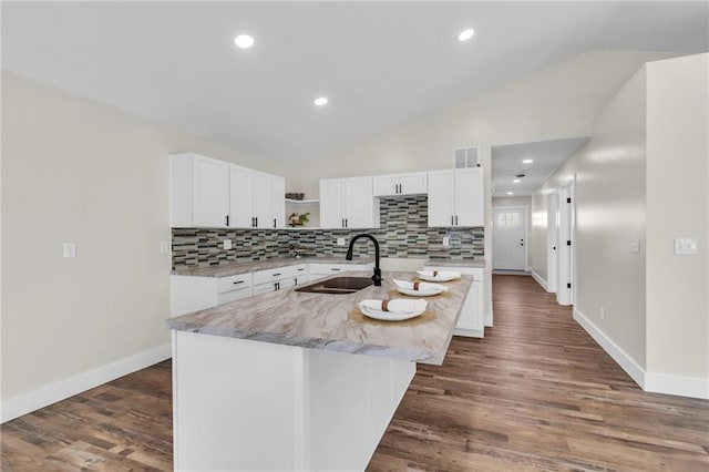 kitchen with sink, a center island with sink, and white cabinets