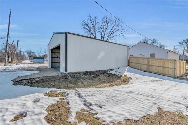 snow covered structure with a garage