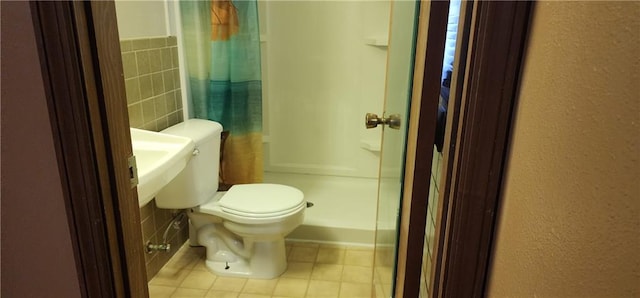 bathroom featuring a shower with curtain, tile walls, and toilet