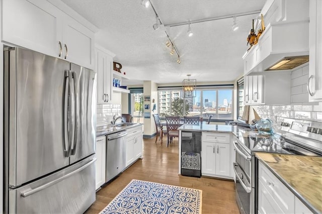 kitchen with sink, decorative backsplash, dark hardwood / wood-style flooring, white cabinetry, and stainless steel appliances