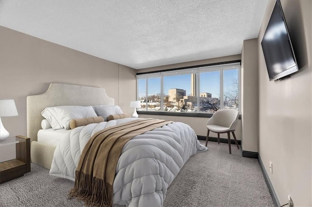 bedroom featuring a textured ceiling, baseboards, and carpet flooring