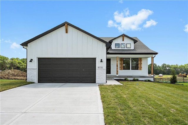 modern farmhouse style home featuring a front lawn, covered porch, and a garage