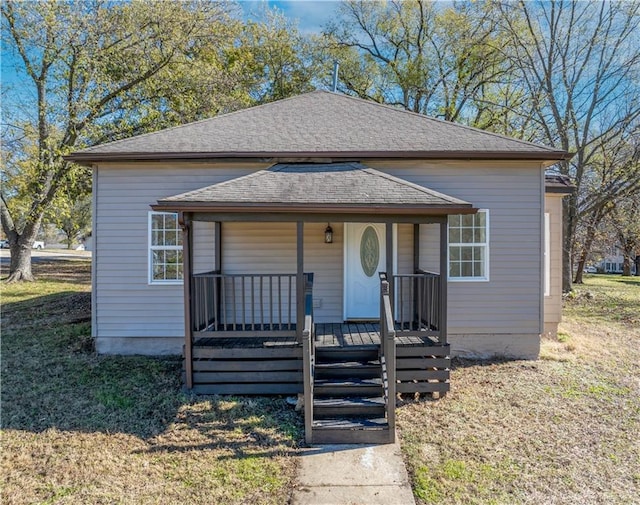 bungalow-style home with covered porch and a front lawn