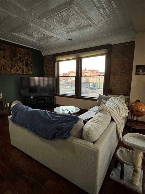 interior space with brick wall and dark hardwood / wood-style floors