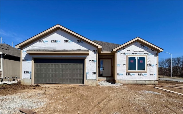 property under construction with a garage, dirt driveway, and a shingled roof