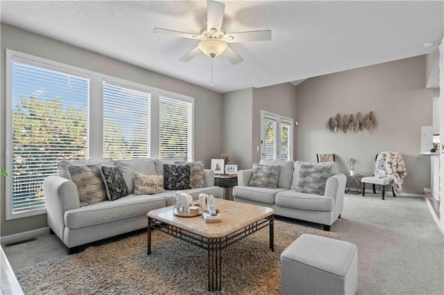 carpeted living room featuring a textured ceiling, ceiling fan, and a healthy amount of sunlight