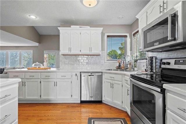 kitchen featuring sink, white cabinets, a healthy amount of sunlight, and appliances with stainless steel finishes