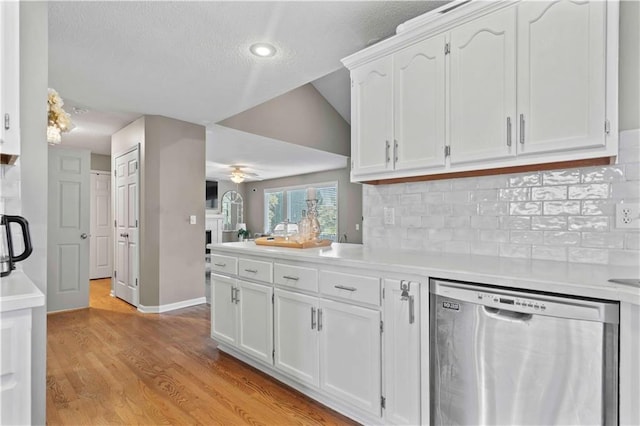 kitchen featuring backsplash, white cabinetry, stainless steel dishwasher, and light hardwood / wood-style floors