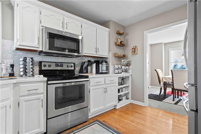 kitchen featuring white cabinets, light wood-type flooring, and appliances with stainless steel finishes