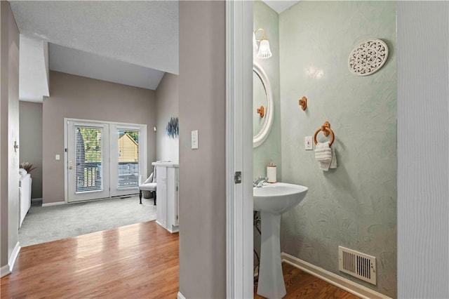 bathroom with hardwood / wood-style flooring, sink, and a textured ceiling