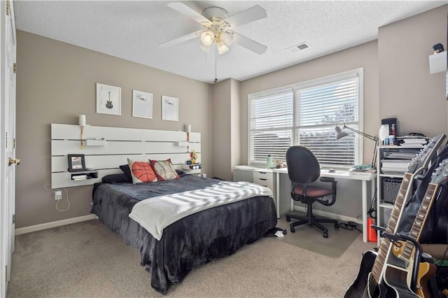 bedroom featuring a textured ceiling, ceiling fan, and light carpet