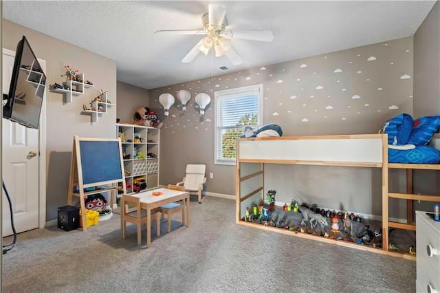 playroom featuring carpet flooring, ceiling fan, and a textured ceiling