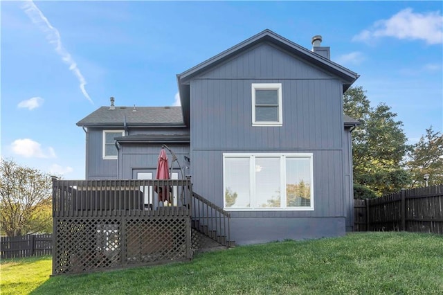 rear view of property featuring a yard and a deck