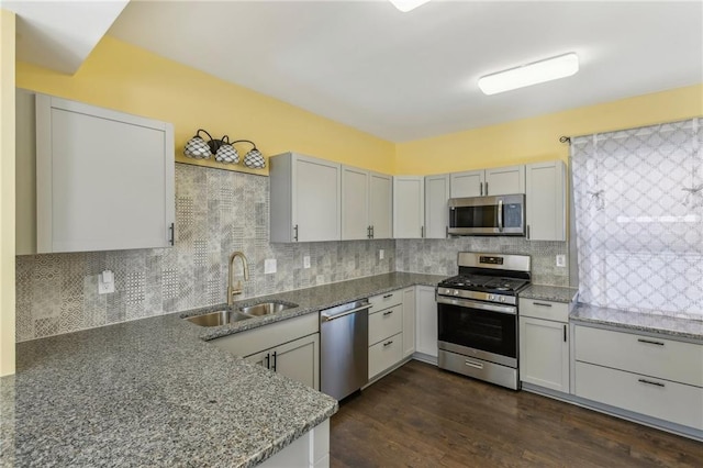 kitchen featuring light stone counters, sink, appliances with stainless steel finishes, and tasteful backsplash