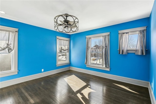 spare room with wood-type flooring and a notable chandelier