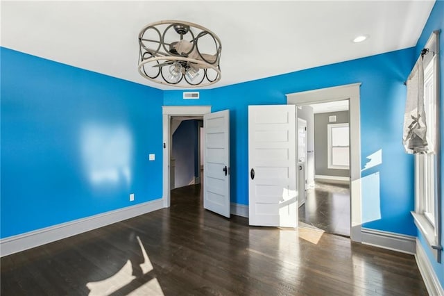 unfurnished room featuring dark wood-type flooring and a chandelier