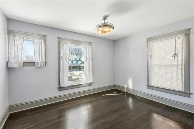 empty room with dark hardwood / wood-style flooring