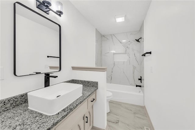 full bathroom with tiled shower / bath, vanity, and toilet