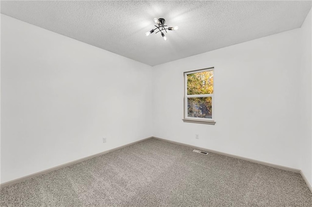 carpeted spare room with a textured ceiling