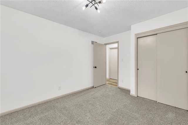 unfurnished bedroom featuring a closet, light colored carpet, and a textured ceiling