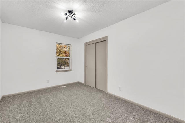 unfurnished bedroom with a closet, carpet floors, and a textured ceiling