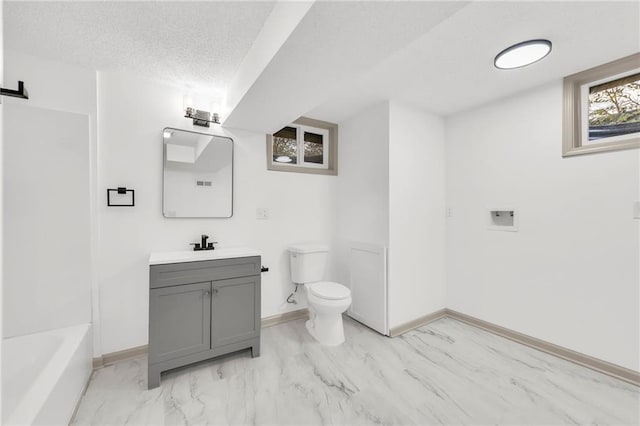 bathroom with a textured ceiling, vanity, and toilet